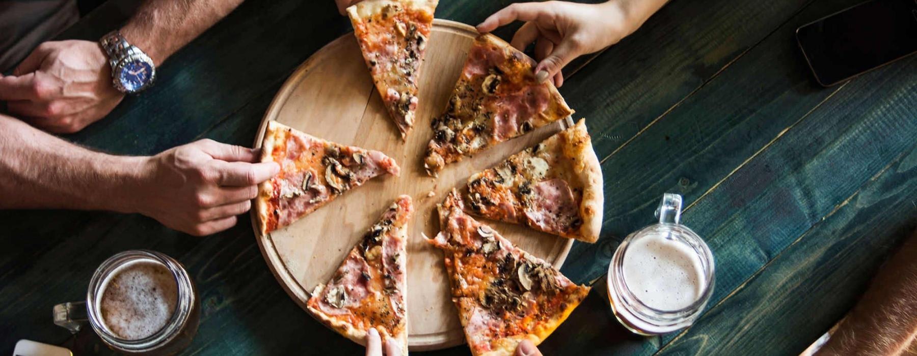 a group of people eating pizza